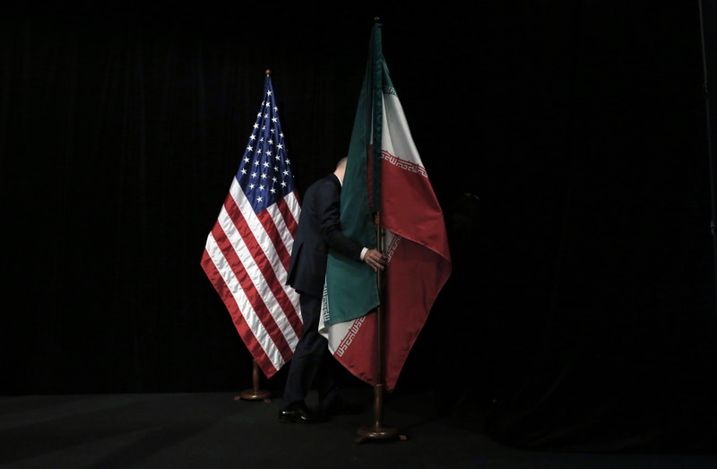 A staff member removes the Iranian flag from the stage after a group picture with foreign ministers and representatives of United States and P5 countries has taken during the Iran nuclear talks at the Vienna International Center in Vienna.