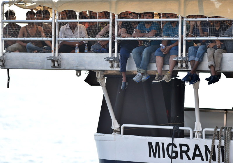Migrants wait to disembark from the Migrant Offshore Aid Station (MOAS) vessel Phoenix, at the harbor of Messina, Sicily, Italy, Wednesday, July 15, 2015. (AP Photo)
