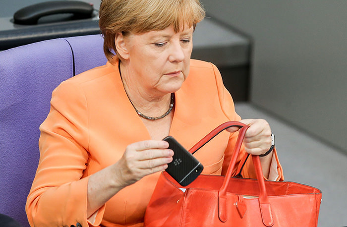 German Chancellor Angela Merkel taking her mobile phone out of her handbag during a parliamentary session in Berlin, Germany (EPA Photo)
