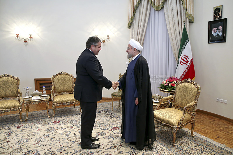 German Vice Chancellor and Economy Minister Sigmar Gabriel (L) shakes hands with Iran's President Hassan Rouhani (R)