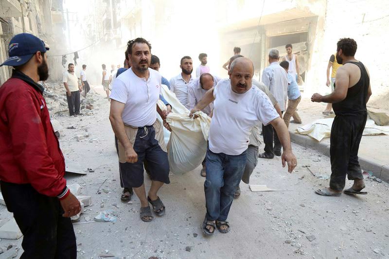 Syrians carry the dead bodies of their relatives in Aleppo after a barrel bomb was dropped by regime.