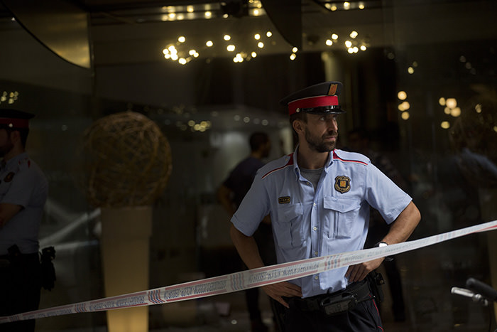 A police officer stands guard at the entrance of a hotel following a shooting in Barcelona, Spain, Tuesday, July 28, 2015 (AP Photo)