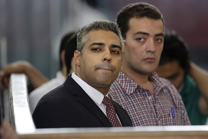 Canadian Al-Jazeera English journalist Mohammed Fahmy, left, and his Egyptian colleague Baher Mohammed listen in a courtroom in Tora prison in Cairo, Egypt (AP Photo)