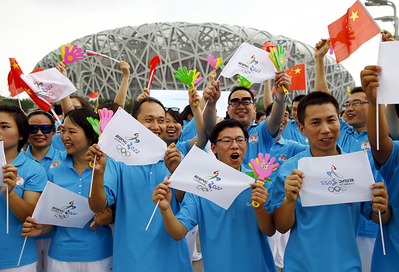  Participants holding Chinese national flags and Beijing 2022 Olympic flags cheer, ahead of IOC's announcement of the winner city for the 2022 winter Olympics bid, in Beijing, China, July 31, 2015 (Reuters photo)