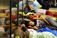Migrants sleep outside a train station in Budapest, Hungary, Aug. 3.