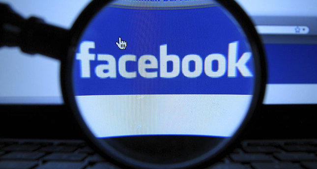 A magnifying glass is posed over a monitor displaying a Facebook page in Munich (AP Photo)