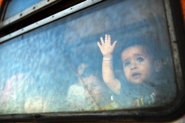 A migrant boy looks through a window onboard a train for Serbia at the new transit center for migrants at the border line between Greece and Macedonia near the town of Gevgelija on August 28, 2015 (AFP photo). 