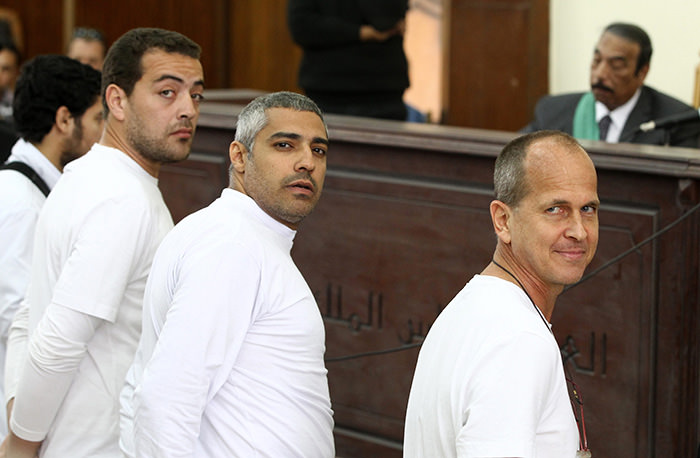 Al Jazeera journalists stand in front of the judge's bench during their trial for allegedly supporting a terrorist group and spreading false information, in Cairo (EPA Photo)