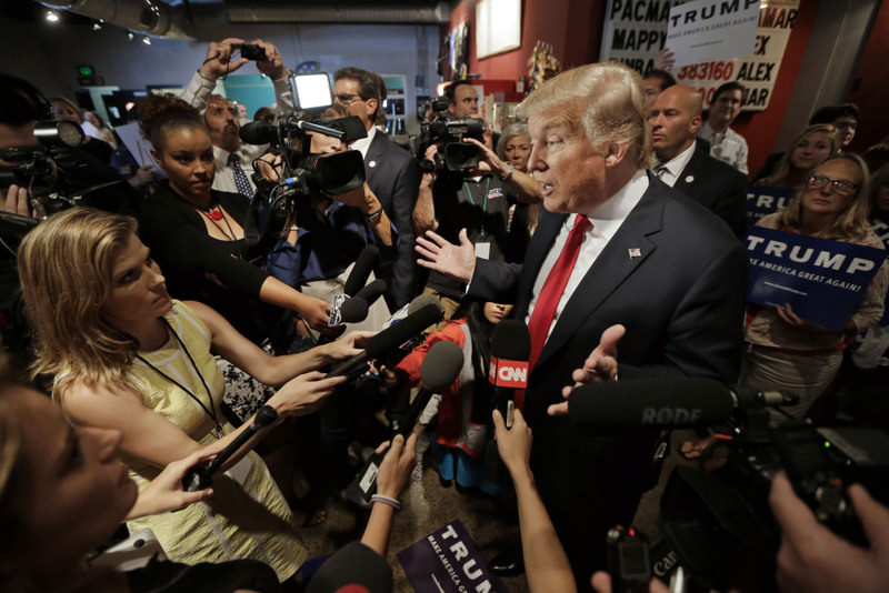 Republican presidential candidate Donald Trump answers questions from reporters after speaking at the National Federation of Republican Assemblies.