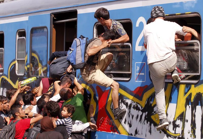 Migrants push and climb through windows to get onto a train bound for Zagreb at the train station in Beli Manastir, Croatia.