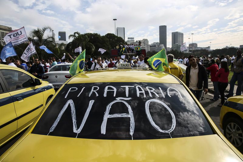 No piracy' written in Portuguese on the windscreen of a taxi as drivers protest against the Uber car service, in Rio de Janeiro, Brazil, 24 July 2015. (EPA Photo)