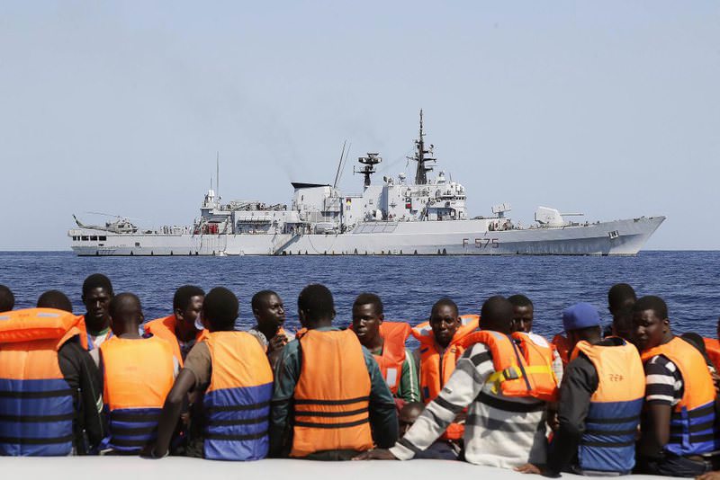 Sub-Saharan migrants (front) being transported to an Italian Navy vessel (background) during a rescue operation in the southern Mediterranean Sea, Sept. 6, 2014.
