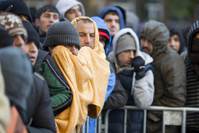 Refugees and migrants try to keep warm during temperatures around freezing as they wait to register and be allocated a sleeping place on the premises of the State Office of Health and Welfare (LaGeSo) in Berlin, Germany.