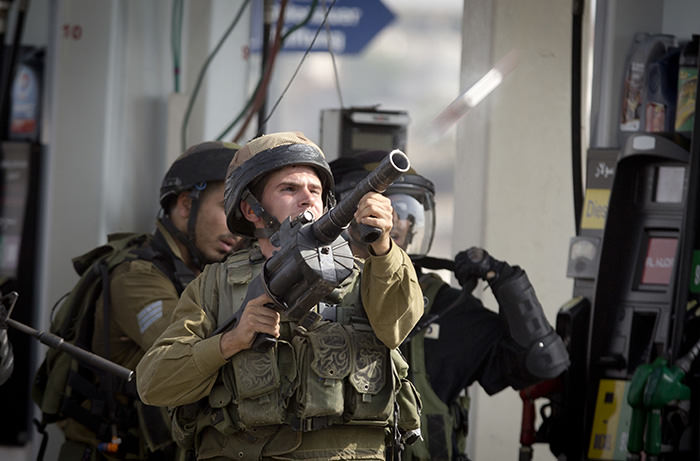 An Israeli soldier fires a tear gas canister during clashes with Palestinian protesters near Ramallah, West Bank, Monday, Oct. 12, 2015 (AP Photo)