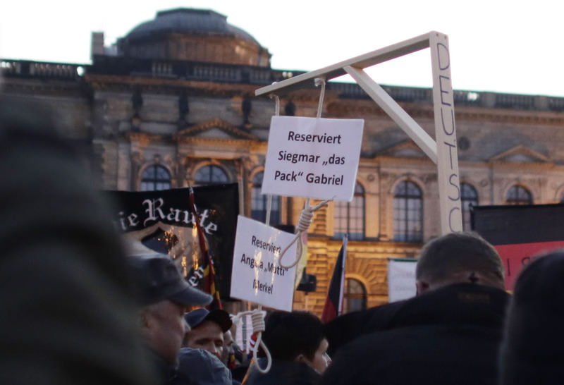 A demonstrator carries a mock gallows with two hangman's nooses, marked: ,Reserved for Angela Merkel,, and ,Reserved for Sigmar Gabriel,, her deputy, at a PEGIDA demonstration in Dresden.