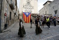Extras make their way to Girona Cathedral, walking pass a Catalonia pro-independence flag while taking part in the filming for Season 6 of the HBO TV series ,Game of Thrones, in Girona, northeast of Spain.