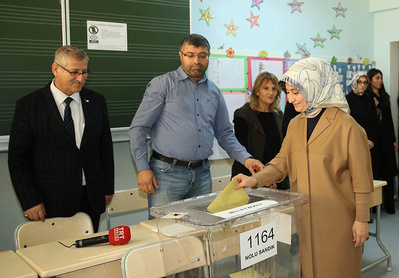 A handout picture provided by the Prime Minister's Office shows Sare Davutoğlu (R) wife of Prime Minister Ahmet Davutoğlu (not pictured) casting her ballot at a polling station in Ankara