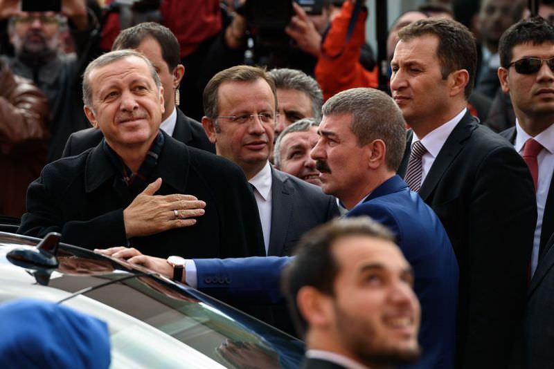 Erdou011fan gestures to supporters after casting his ballot for the elections at a polling station in Istanbul