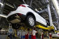 Workers assemble a Porsche Cayenne model on the production line at the plant of German luxury carmaker Porsche, a Vokswagen brand, in Leipzig, Germany.