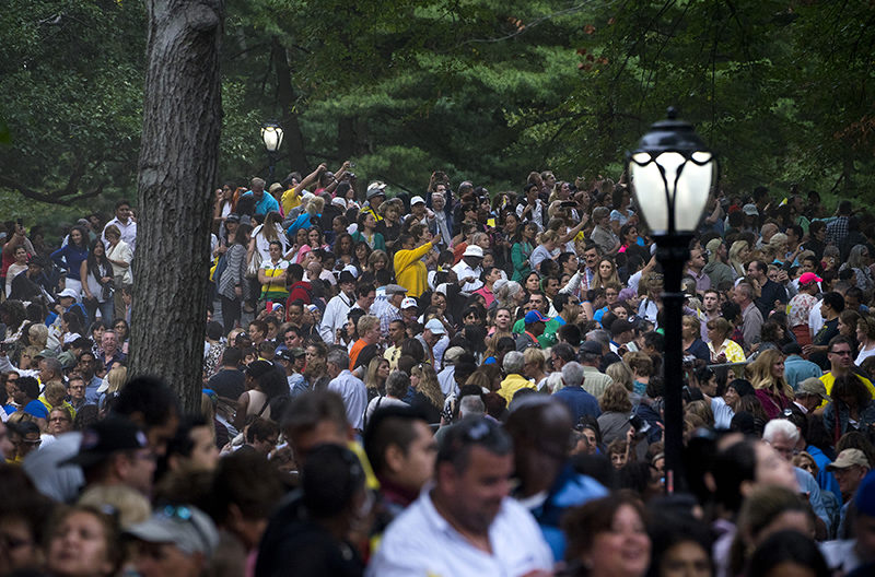 People in a large crowd reach out to get photographs as Pope Francis passing while traveling in a motorcade in New York's Central Park, Friday, Sept. 25, 2015. (AP Photo)