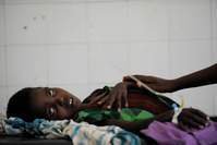 Bisharo Hurow, 10, lays on a cot at a hospital in Mogadishu while suffering from severe diarreah and vomit on August 15, 2011. (AFP Photo)