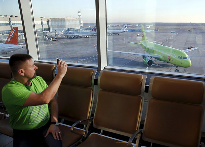 A man takes pictures, with a plane (R) of S7 airlines seen in the background, at Domodedovo airport outside Moscow, Russia, November 6, 2015 (Reuters Photo)