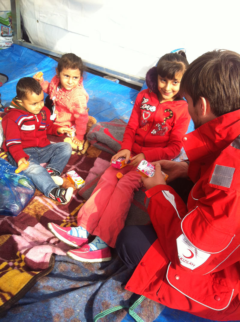 Güllüoğlu speaking with children in refugee camps.