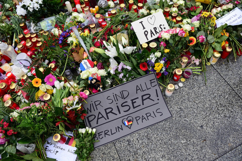 A message reads , We are all Parisians - Berlin loves Paris , amount flowers and candles on the ground outside the French embassy in Berlin, on November 16, 2015. (AFP Photo)