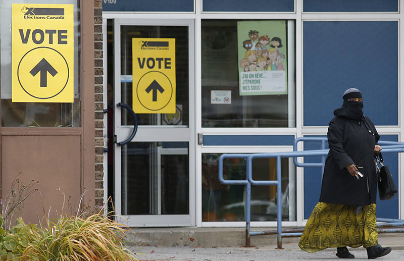 A woman wearing a niqab leaves the Ecole Marius-Barbeau polling station in Ottawa, after casting her vote in the Canadian federal election on Monday, Oct. 19, 2015 (AP Photo)
