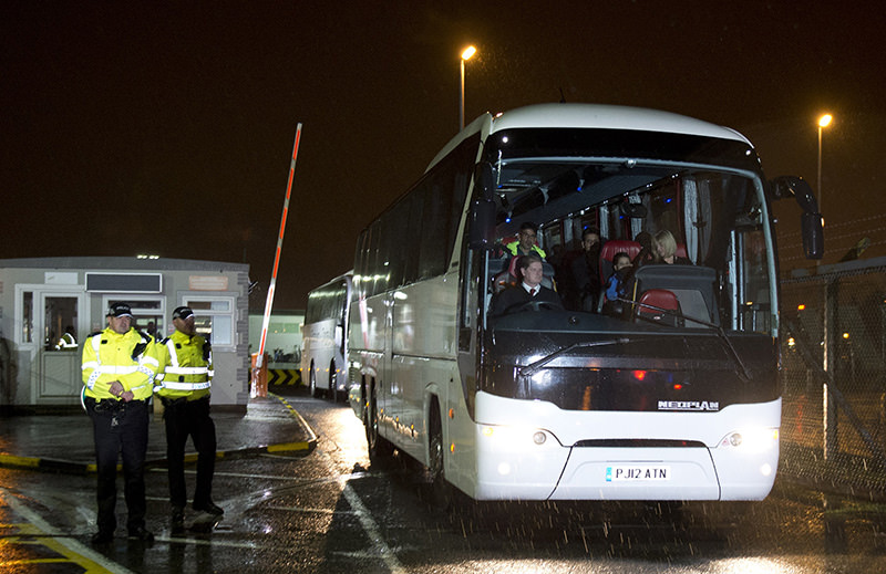 Syrian refugees are driven away in a convoy of buses after landing at Glasgow airport, Scotland on November 17, 2015 (AFP Photo)