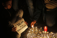 A boy holds a banner reading in Catalan: ,Islam is not terrorism,, during a demonstration, called by the IBN Battuta Foundation on behalf of the Muslim community to show solidarity with the victims of the terror attacks of Paris.