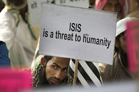 An Indian Muslim man holds a banner during a protest against ISIS (aka Daesh), and Friday's Paris attacks, in New Delhi, India, Wednesday, Nov. 18, 2015 (AP Photo)