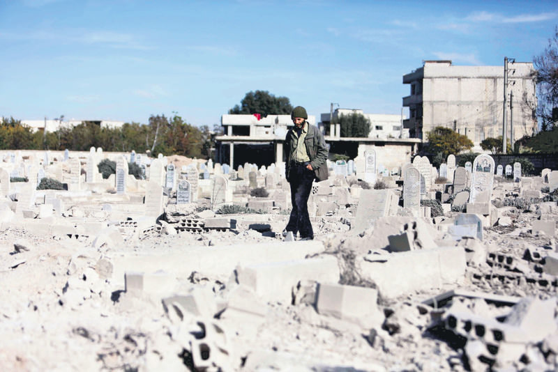 A man walking in a graveyard of destroyed graves in a neighbourhood heavily damaged by Russian airstrikes in the moderate-held region of eastern Ghouta, Syria.