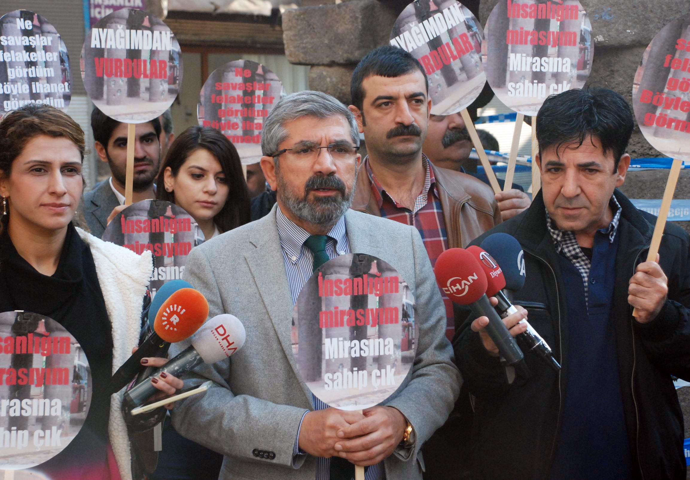 Elçi (C) holds a banner that reads 'I'm a humanity's heritage, look after your heritage' during the press release right before the attack. (IHA Photo)