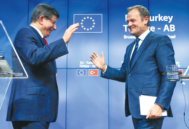 Prime Minister Davutou011flu (L) and European Council President Tusk greet each other after a news conference following a EU-Turkey summit in Brussels on Sunday.