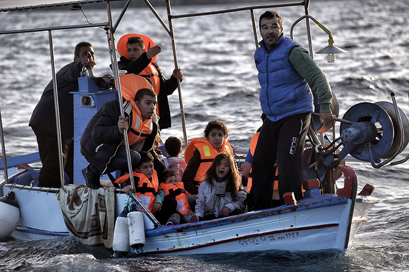 Greek fishermen rescuing Syrian refugees as the boat they boarded sank off Greek island of Lesbos after crossing Aegean sea from Turkey on Oct 30, 2015 (AFP photo).