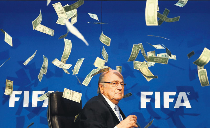 British comedian known as Lee Nelson (unseen) throws banknotes at FIFA President Sepp Blatter as he arrives for a news conference after the Extraordinary FIFA Executive Committee Meeting at the FIFA headquarters in Zurich, Jul. 20, 2015.