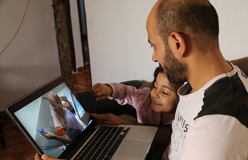 In this picture taken on Saturday, Nov. 28, 2015, Abdul Halim al-Attar, a refugee from Syria sits next his daughter Reem, 4, as they look at a photo on a laptop during an interview with The Associated Press (AP Photo)