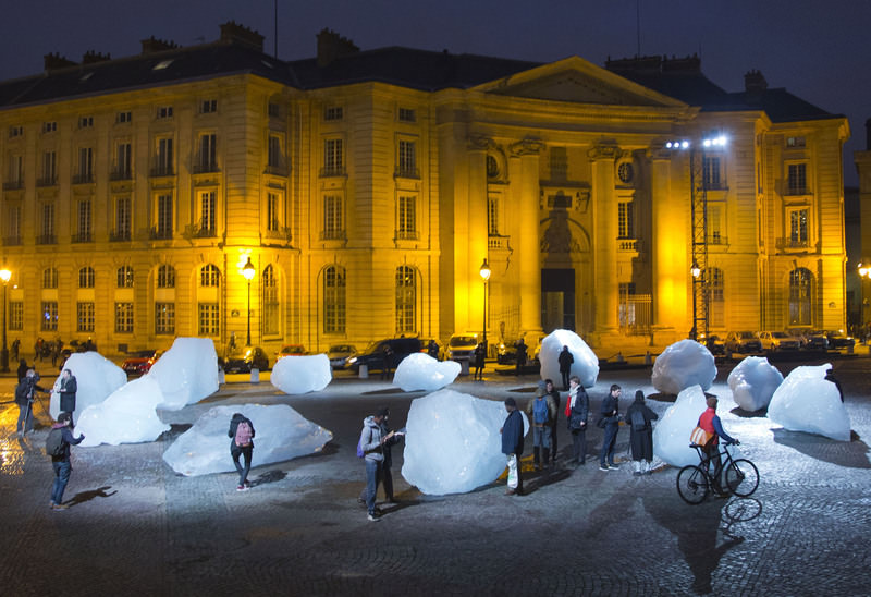 Visitors walks through ice blocks part of the sculpture ,Ice Watch,, by Danish artist Olafur Eliasson, Thursday Dec. 3 2015 in Paris. (AP Photo)