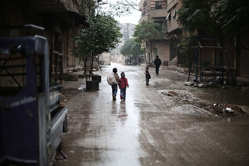 Syrian children walk in the rain in the town of Saqba, on the outskirts of the capital Damascus, on November 17, 2015 (AFP photo)