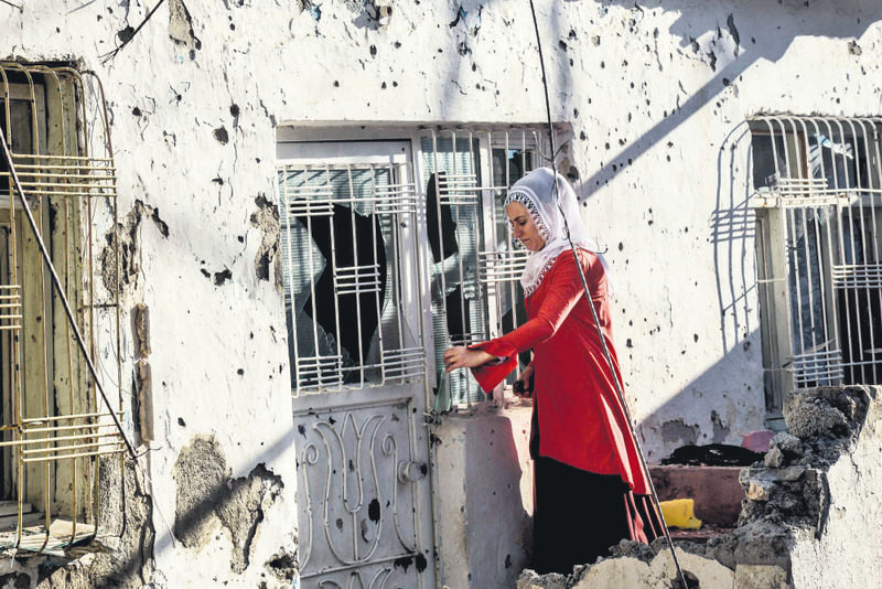 A Kurdish woman trying to open the door of her home in Silvan, a southeastern district of Turkey, after clashes between security forces and Kurdish militants