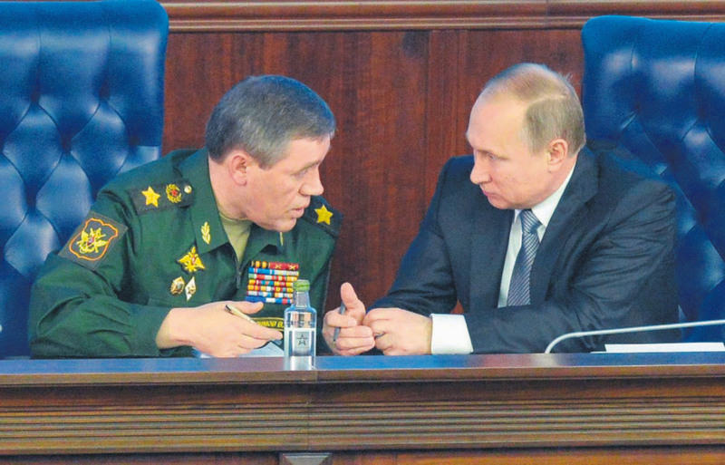 Russian President Putin (R) talks with the Chief of Russian army general staff Gerasimov (L), during a Defence Ministry board meeting in Moscow on Friday.