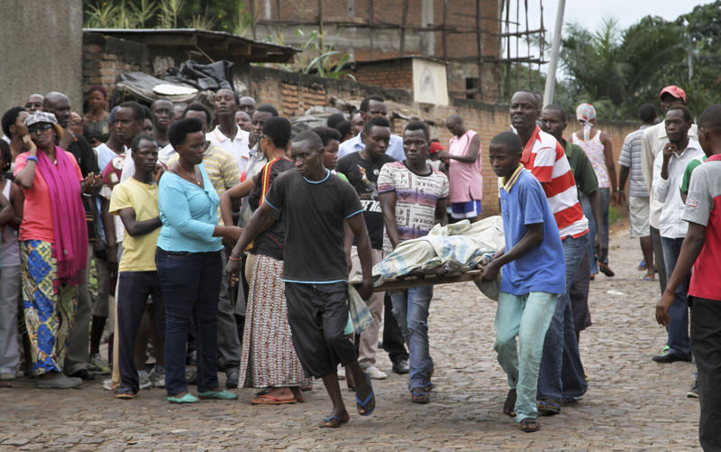 Men carry away a dead body in the Nyakabiga neighborhood of Bujumbura, Burundi, Saturday, Dec. 12, 2015 (AP Photo)