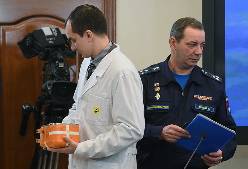 A specialist takes away the flight recorder from the Russian Sukhoi Su-24 bomber in Moscow on December 18, 2015 (AFP photo)