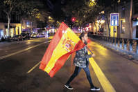 A supporter of the Popular Party carries a Spanish flag as she leaves the party headquarters in Madrid on Sunday.