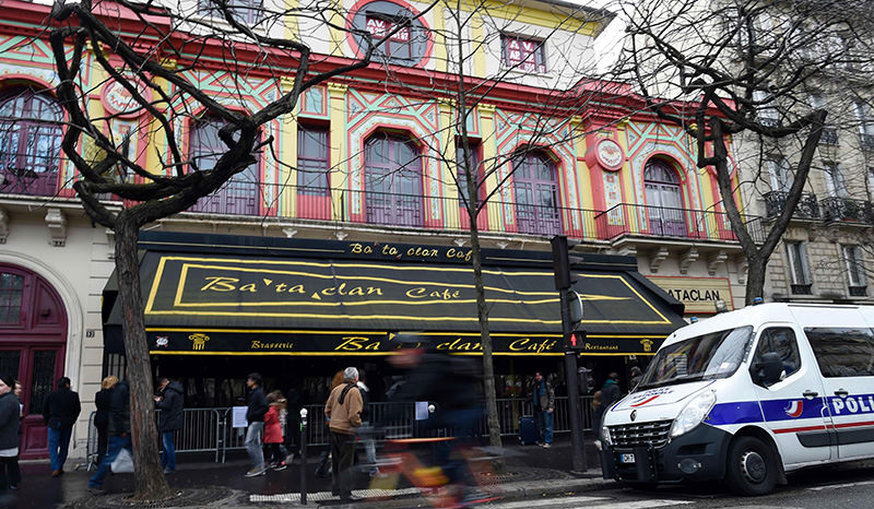People stand in front of the Bataclan concert hall in Paris on December 24, 2015, after the sidewalk in front of the venue was once again made accessable to pedestrians (AFP Photo)