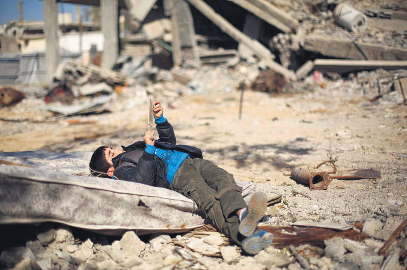 A Palestinian boy lies on a matress amid the rubble of buildings that were destroyed during the 50-day Israeli agression in the summer of 2014 in Gaza City's Al-Shejaiya neighborhood.