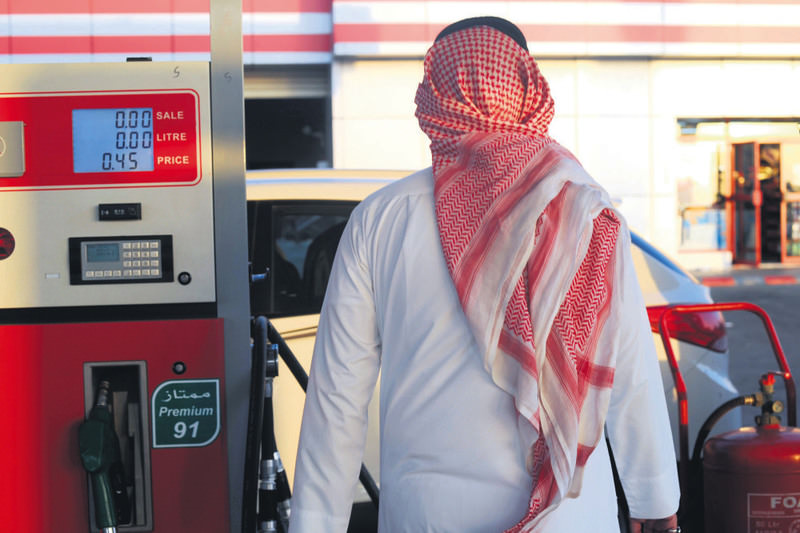 A Saudi man walks past a pump at a gas station on Monday in the Red Sea city of Jeddah. Gasoline prices in the kingdom rise more than 50 percent on Tuesday.