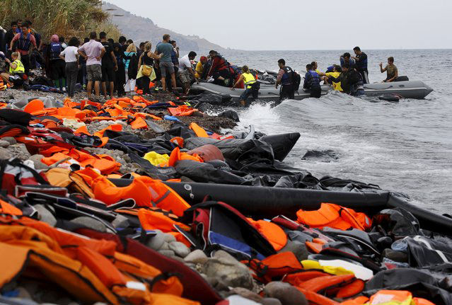 Syrian refugees arrive on the Greek island of Lesbos in an overcrowded dinghy after crossing a part of the Aegean Sea from the Turkish coast September 22, 2015. (REUTERS Photo)