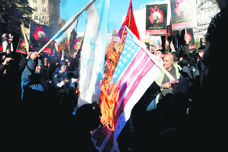 A group of Iranian protesters in Tehran torched Israeli and U.S. flags in order to show their anger at al-Nimr's execution. (AP Photo)